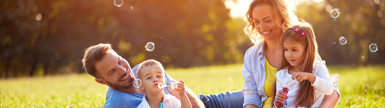 Family blowing bubbles in a field