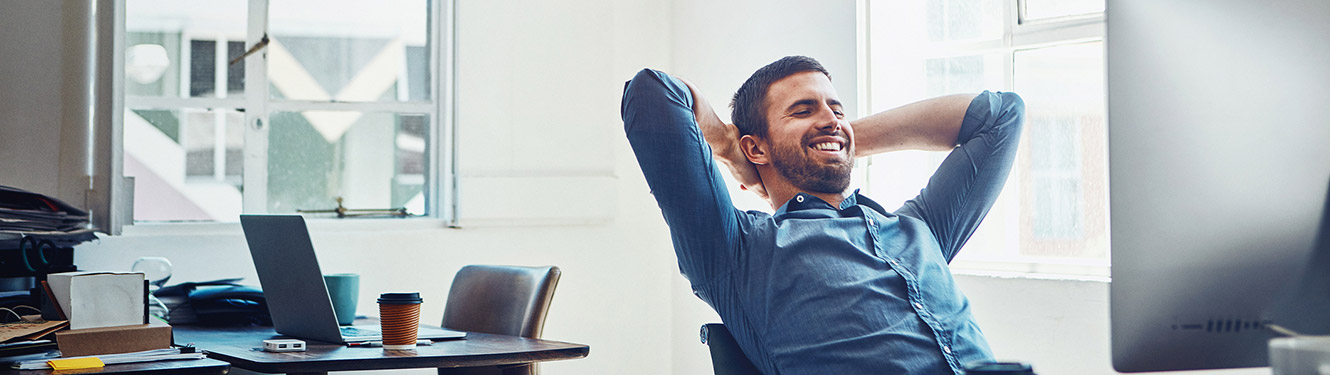 Man smiling at work at a desktop computer